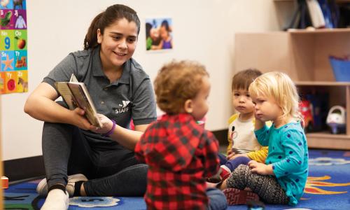 YMCA Staff member reads a story to preschoolers