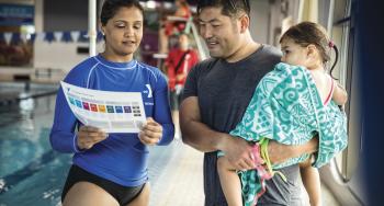 Swim instructor speaking to parent and child
