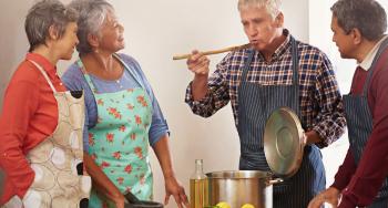 4 senior-aged people cooking together